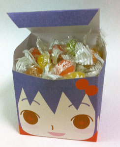 a cute cube-style anime face gift box filled with colorful wrapped candies, example 4